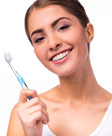 woman with braces and toothbrush smiling